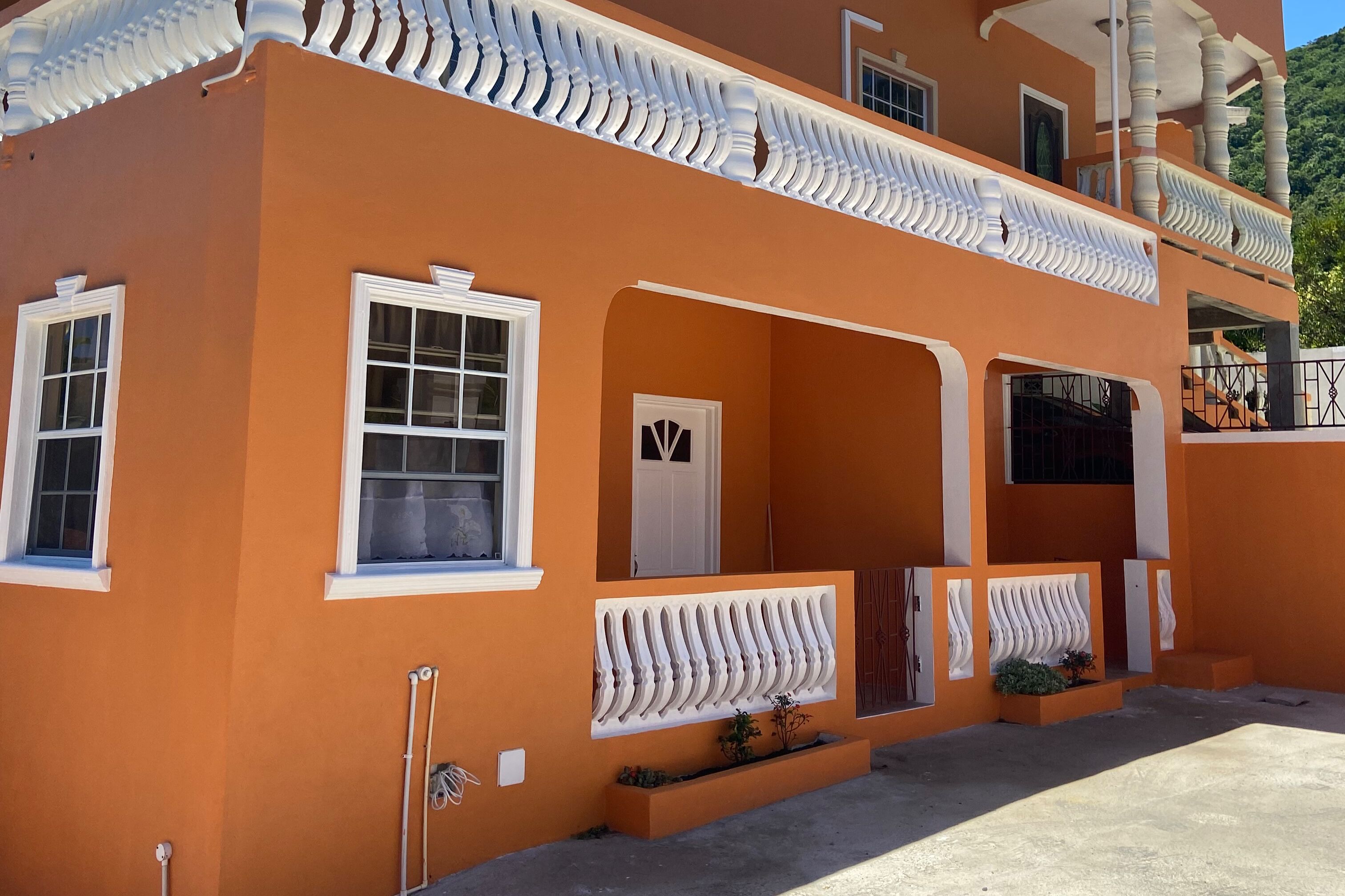 A two-story building with a flat roof and white decorative trim.