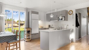 A modern kitchen with a central island, built-in appliances, and large windows.