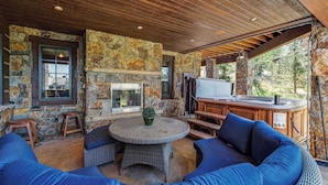 Une terrasse extérieure avec des murs en pierre, un foyer et un espace barbecue.