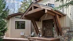 Ein Haus mit Steinfundament, einer Holzveranda und einer einladenden Haustür.