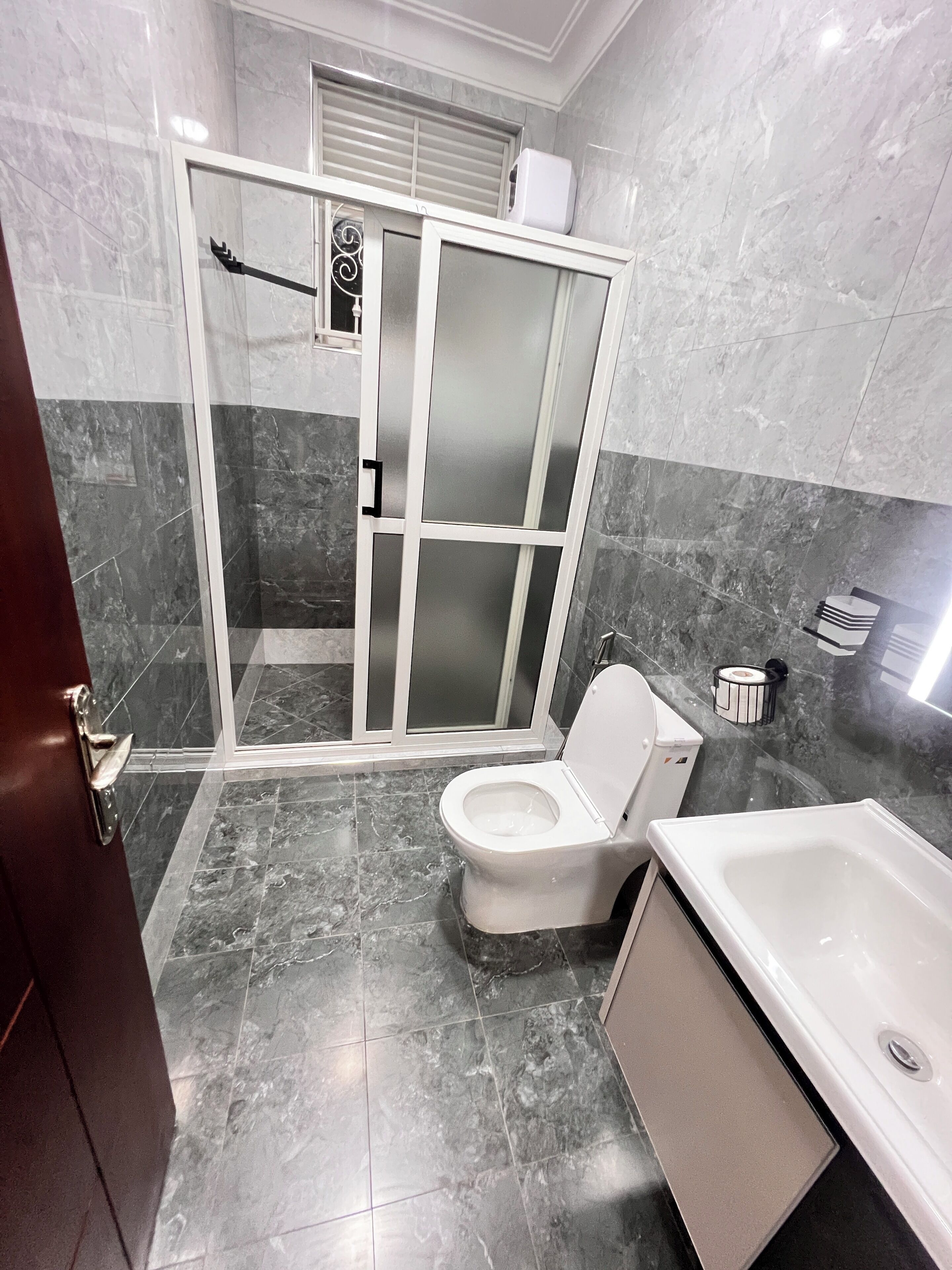 A bathroom with a toilet, shower enclosure, and bathtub.