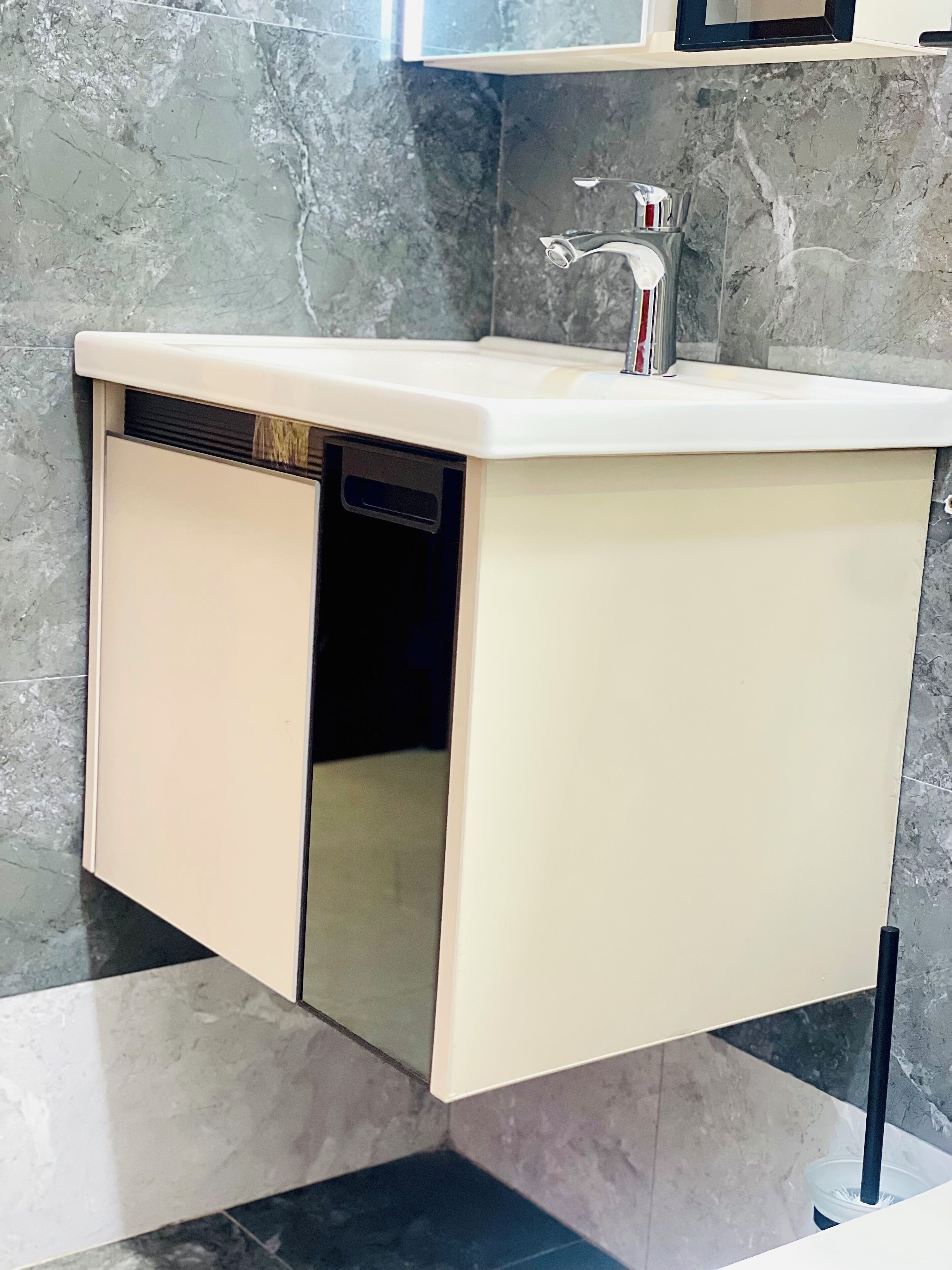 Un baño pequeño con lavamanos integrado, espejo y retrete.