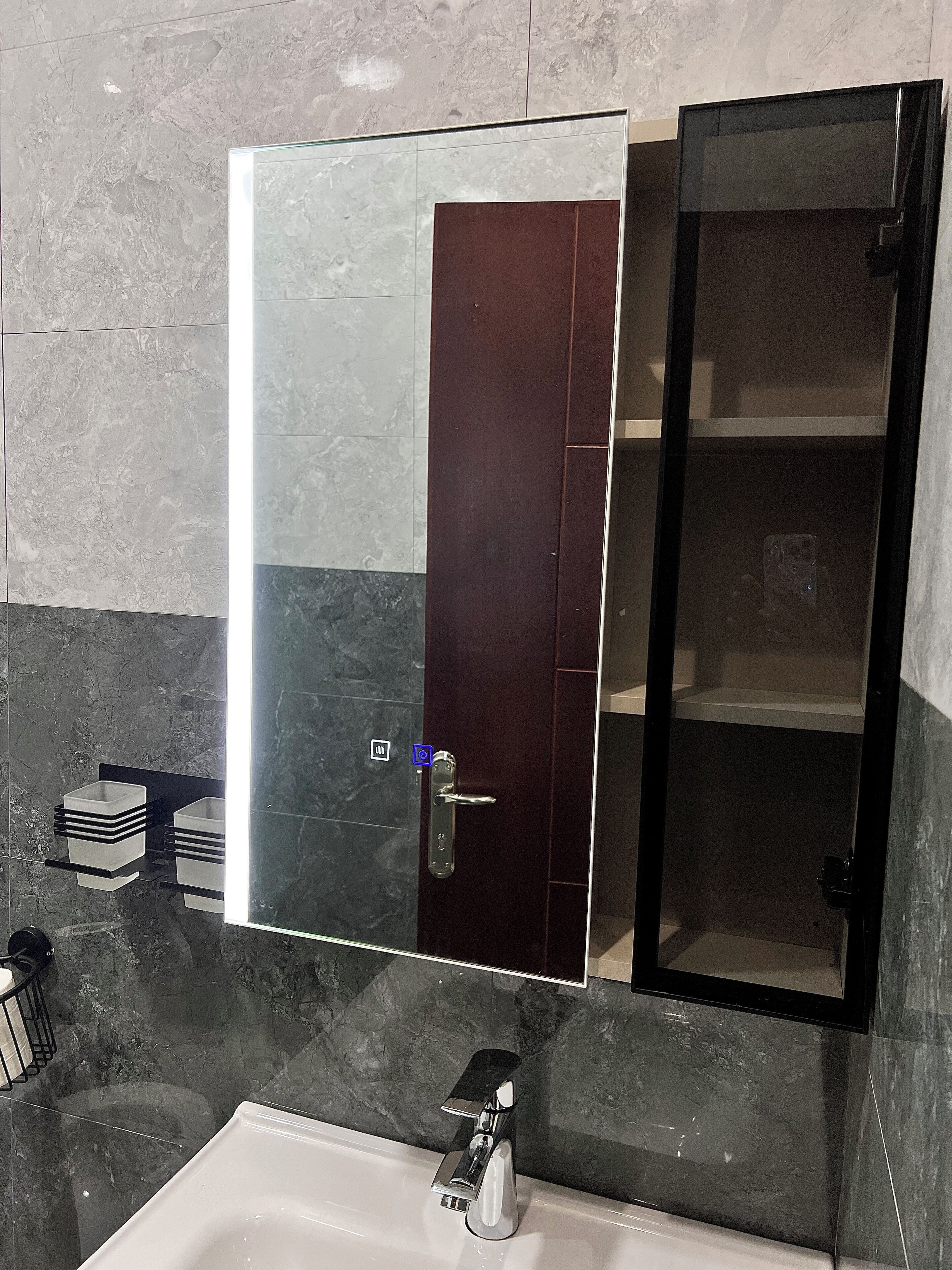 A bathroom with a large mirror, a modern sink, and a dark door.