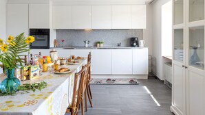 Eine moderne Küche mit weißen Schränken, einer Granit-Arbeitsplatte und einem Essbereich mit gedecktem Frühstückstisch.