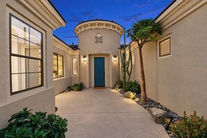A building with a central blue door, a circular structure above it, and a pathway leading to the door. - Wonderscape - Lion Slide, Arcade, Pickleball, Spa (Indio)