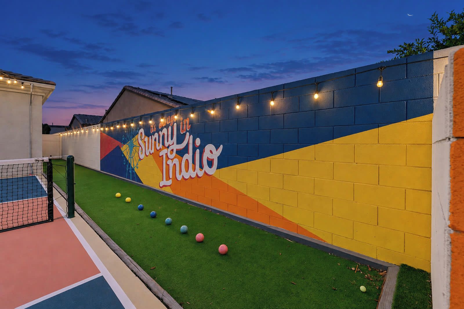 A wall with a colorful mural and a mini-golf setup.