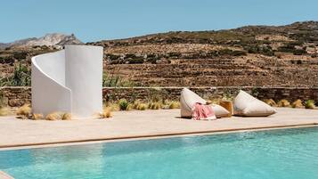 Una piscina al aire libre de temporada, sombrillas