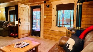 Ein Holzinnenraum mit einer Couch, einem Tisch und einem Kamin.