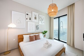 Una habitación de hotel moderna con una cama grande, vistas a la ciudad y obras de arte en la pared.