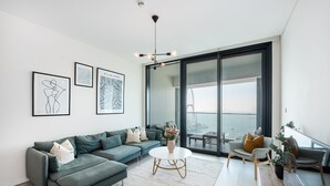 Ein modernes Wohnzimmer mit einer Couch, einem Couchtisch und Blick auf eine Brücke durch große Fenster.