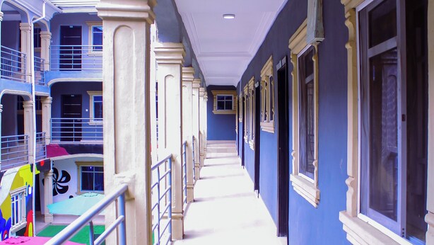 A corridor with a blue wall, white trim, and multiple windows. - BON HOMES (Ibadan)
