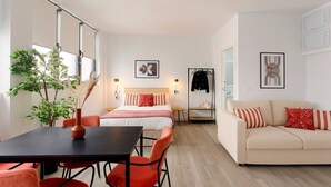 Une chambre d’hôtel moderne équipée d’un lit, d’un canapé, d’une table à manger et de chaises.
