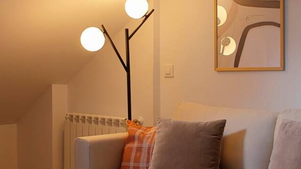 Een moderne woonkamer met een bank, een radiator en een vloerlamp.