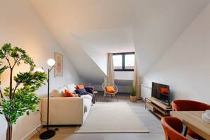 A modern loft apartment with a high ceiling, a dining area, a sofa set, a television, and a large window. - 644D2 Apartamento 5p Sobrecantu (Oviedo)