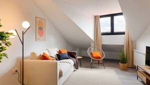 A modern living room with a sofa, a chair, a floor lamp, and a television. - 644D2 Apartamento 5p Sobrecantu (Oviedo)