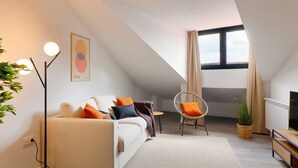 A modern living room with a sofa, a chair, a floor lamp, and a television. - 644D2 Apartamento 5p Sobrecantu (Oviedo)