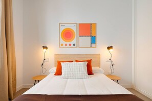 Ein Hotelzimmer mit einem Bett, zwei Nachttischen, einem Kopfteil und zwei Wandlampen.