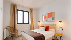 A bedroom with a bed, a chair, a table, a window with curtains, and wall art. - 644D2 Apartamento 5p Sobrecantu (Oviedo)