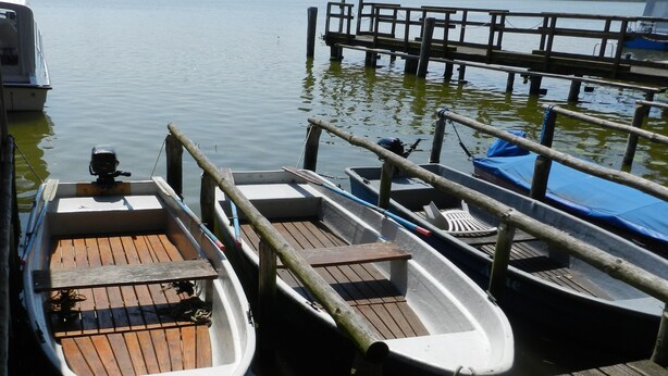 Un muelle de madera con varias embarcaciones amarradas.