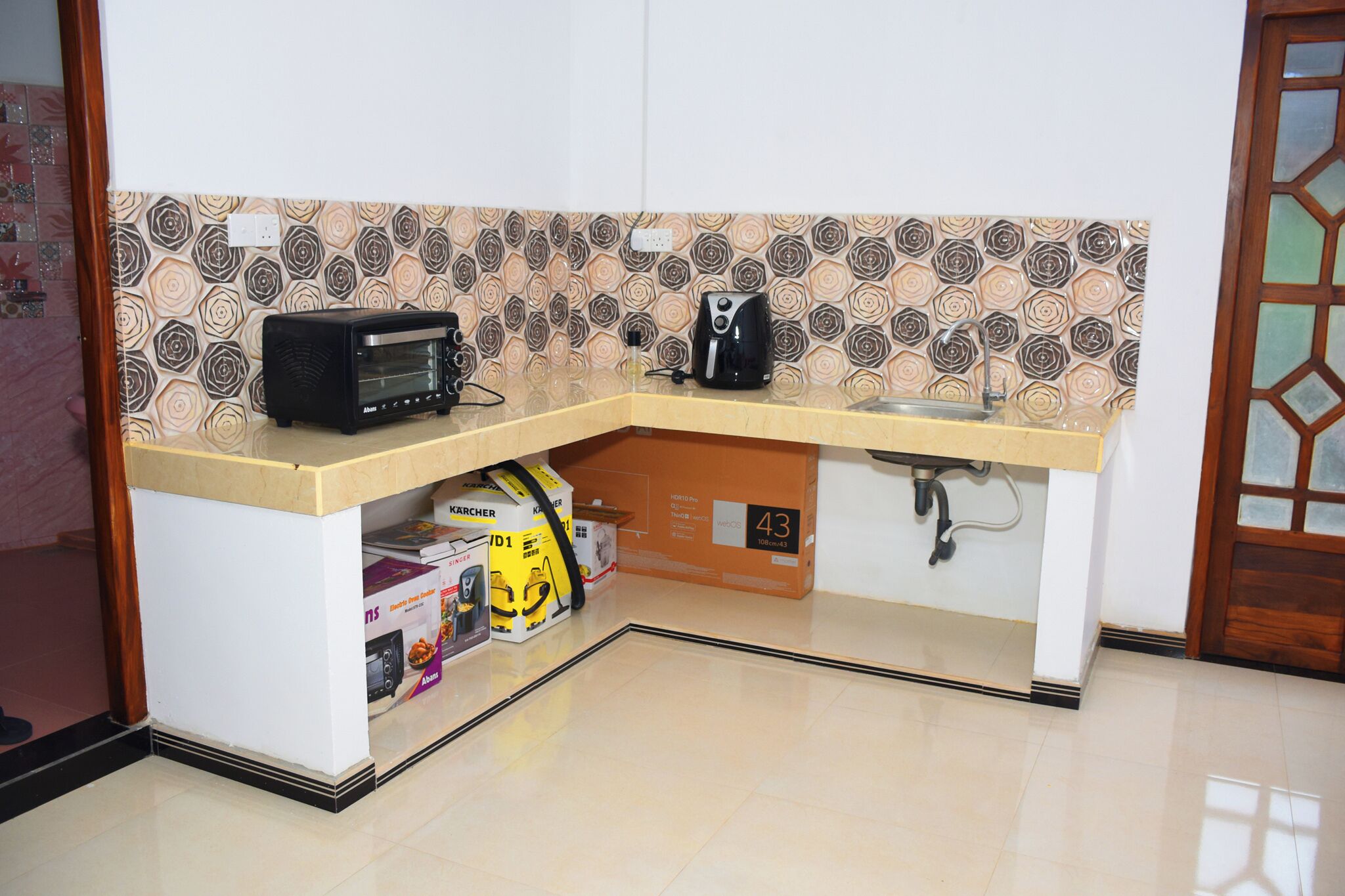 Una cocina compacta con microondas, tostadora y cafetera integradas en la encimera.