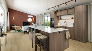 A modern kitchen with a central island, bar stools, and a dining area with a sofa and table.