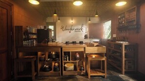 A cozy kitchen with wooden shelves, hanging lights, and a sign reading "Wonderwerk Kitchen".