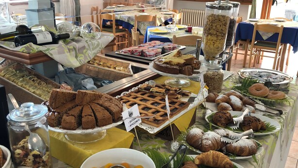 Un buffet proposant une variété de plats, notamment des gâteaux, des pâtisseries et différents types de desserts.