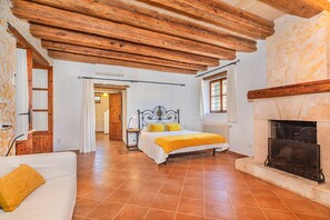 Une chambre à coucher avec un lit, une cheminée et un plafond en bois.