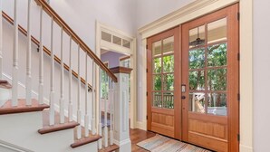 A wooden staircase with white balusters leading to a landing. - Seaclusion at the Beach (Pawleys Island)