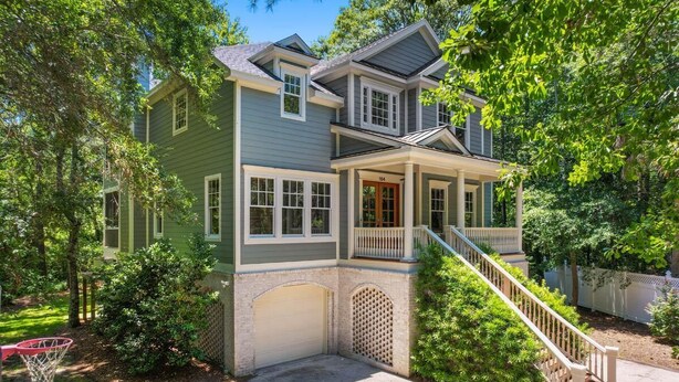 A two-story house with a front porch, a garage, and a basketball hoop in the yard. - Seaclusion at the Beach (Pawleys Island)