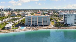 Ein Küstenhotel mit einem großen Gebäude, einem Pool und Strand.