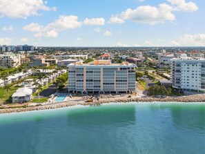 A coastal hotel with a pool, beachfront view, and multiple buildings in the background. - Dela Park Place - Waterfront 2BDR/2BA with Den (Marco Island)
