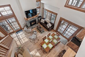 A spacious living area with a fireplace, a television, and a dining table set for six.