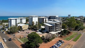 A coastal urban area with modern buildings, a parking lot, and a clear view of the sea. - Katara on Smith (Darwin)