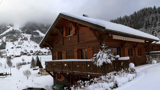 A wooden chalet with a balcony, surrounded by snow-covered mountains. - Spacious chalet with WIFI, pets allowed, private garage (Abondance)
