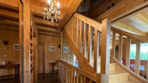 A wooden interior with a staircase, wooden walls, and a chandelier. - Spacious chalet with WIFI, pets allowed, private garage (Abondance)