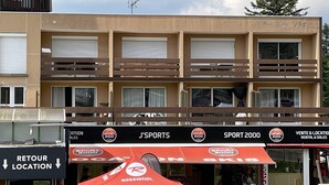 A multi-story building with signage for 'J'SPORTS' and 'SPORT 2000'. - Cozy T2 in Station Center, Near Shops and Slopes (Le Lioran)