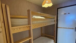 A bunk bed with a ladder, a door, and a hanging light fixture. - Ski-in/Ski-out Studio, South-East Balcony, Sleeps 4, Shops Onsite (Le Lioran)