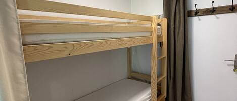 A bunk bed with a wooden frame and a single mattress.