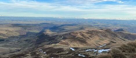 A panoramic view of a mountainous landscape with a clear sky.