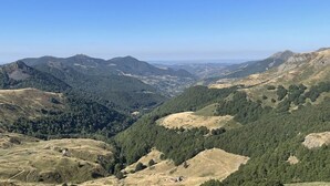 A mountainous landscape with a valley and forested areas. - Ski-in/Ski-out Studio with Balcony and WiFi in Laveissière (Le Lioran)