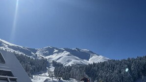 A snow-covered mountain with a ski lift and a building in the foreground. - Ski-In/Ski-Out Studio with Mezzanine, Balcony & Free Shuttle (Le Lioran)