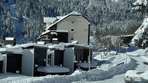 A snow-covered building with multiple rooms, a ski lift, and a snowy landscape. - Studio with Balcony, Equipped Kitchen, Wi-Fi in Le Lioran (Le Lioran)
