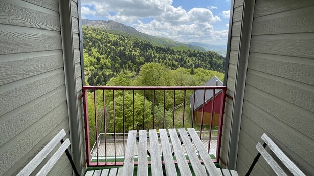 A balcony with a view of a forested mountain range. - Charming duplex near slopes with balcony and parking (Saint-Jacques-des-Blats)
