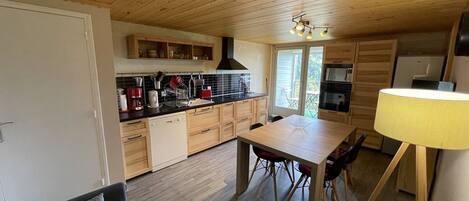 Une cuisine de taille réduite, avec des meubles de rangement en bois, une table à manger et un canapé.