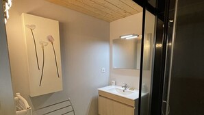 A bathroom with a white sink, a mirror, and a towel rack. - Charming duplex near slopes with balcony and parking (Saint-Jacques-des-Blats)