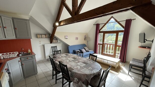 A cozy kitchen with a dining table, chairs, and a built-in oven.