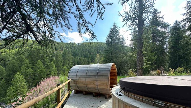 A wooden sauna structure with a bench, set on a wooden deck surrounded by forest. - Apartment Vars, 3 bedrooms, 8 persons (Vars)