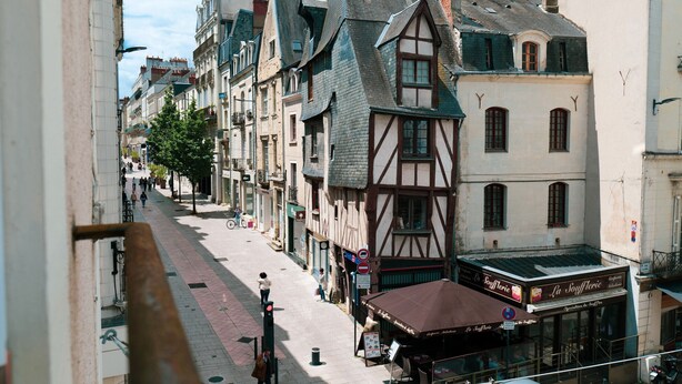 A narrow street lined with traditional half-timbered buildings, a café with outdoor seating, and a pedestrian crossing. - Large studio apartment in the heart of Angers - 2 people (Angers)