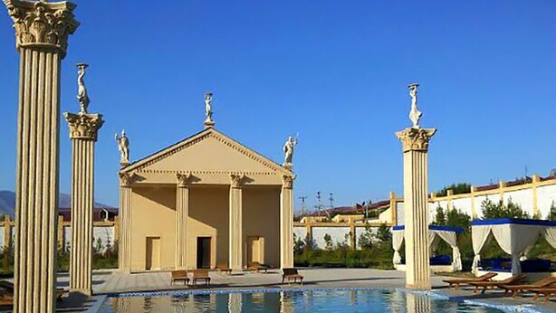 A swimming pool with classical columns and a building with a triangular pediment. - Gumbaz Eco SPA Hotel (Samarkand)